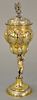 Russian silver gilt chalice having cover with finial, lobbed body held by putti on round base with overall gilt decoration, marked:...