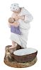 A RUSSIAN PORCELAIN FIGURE OF A PEASANT WOMAN NURSING A BABY, GARDNER PORCELAIN FACTORY, MOSCOW, LATE 19TH CENTURY