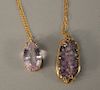 Two large amethysts in 14 karat gold pendant mounts, each on gold plated chains.