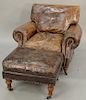Leather upholstered chair and ottoman. ht. 34 in., wd. 41 in.
