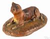 Pennsylvania recumbent redware cat, 19th c., with cream colored paws and lying on an oblong base