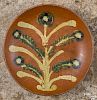 Southeastern Pennsylvania redware charger, 19th c., with a large yellow and green slip tree