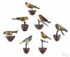 Seven carved and painted songbirds, early 20th c., on twig perches, approx. 5'' h.