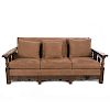 Sofá de tres plazas. Siglo XX. En talla de madera. Con tapicería de tela color marrón. Respaldo cerrado y soportes lisos.