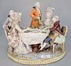 Porcelain group with five people at a table marked with crossed swords (chips and pieces missing). ht. 9 in., lg. 11 in.