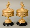 Pair of French gilt bronze compotes with cover, each having molded leaf decoration with crane finial on the cover, both resting on b...