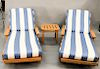 Three piece lot to include pair of Giati Palazzio teak chaise lounge chair with cushions having Sunbrella upholstery and a side tabl...