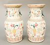 Pair of Famille Rose vases decorated with Buddhist symbols and vases with small foo lion handles.  ht. 13 in.