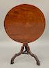 Mahogany Federal tip table with round top on shaft, ending in carved tripod base.  ht. 27 1/2 in., top: 27" x 27 1/2"