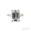 Platinum and Diamond Solitaire, prong-set with an emerald-cut diamond weighing 5.05 cts., flanked by tapered baguettes, size 5 1/4. Not