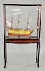 Four piece lot to include HMS Victory ship model, in glass case on stand (ht. 69 in., wd. 40 in.) and three large brass candlesticks.