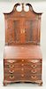 Custom mahogany secretary desk in two parts with carved broken arch top and carved pinwheel over two doors, lower section with slant...