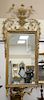 Italian Neoclassical style giltwood mirror, rectangular, surmounted by a scrolled crest and with a scrolled apron. ht. 57 in., wd. 2...