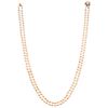 A cultured pearl necklace with a pearl and sapphire 14K yellow gold clasp.