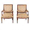 Par de sillones. Francia. Siglo XX. Estilo Luis XV. En talla de madera de nogal. Con respaldos semiabiertos y asientos en tapicería.
