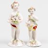 Two Bow or Derby Porcelain Small Figures of Putti Carrying Baskets