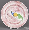 Red spatter plate, 19th c., with a peafowl, 7 1/2'' dia.