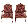 Par de sillones. Francia. SXX. Estilo Luis XV. En talla de madera de nogal. Con respaldos cerrados y asientos en tapicería color rojo.