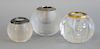 Three glass match strike and holders. two balls with rough ring sides and silver tops and a cut glass ball with brass top. ht. 3 1/4...