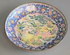 Canton enamel dish with enameled figures at a table in a garden, blue ground, 19th/20th century, dia. 10 1/4 in.