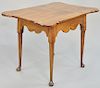 Queen Anne tea table, having porringer top, set on scalloped base set on turned legs ending in pad feet, circa 1750, top probably original but flipped