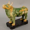 A sancai glazed pottery figure of a caparisoned bull, body glazed green, the trappings glazed in cream and amber. length of wood stand 8 1/2 inches. P