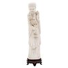 OLD MAN WITH FLOWERS. CHINA, EARLY 20TH CENTURY. Carved ivory with black ink details. 13 in tall.