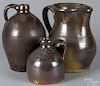 Three brown glazed stoneware pieces, to include a pitcher with a yellow base glaze, 9 1/2'' h.