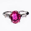 AN 18CT WHITE GOLD RUBY AND DIAMOND RING, the oval cut ruby