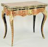 French Boulle and Gilt Bronze Mounted Games Table, 19th century, brass inlaid hinged top, serpentine front, opening to felt lined surface, above confo