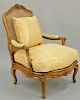 Louis XV French Fauteuil, walnut, having carved crest over caned backs and open arm, and caned seat on cabriole legs having leather upholstered cushio