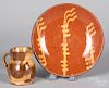 Slip decorated redware pie plate and a creamer