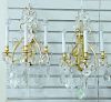 Pair of bronze and crystal sconces, each having three arms with lights and crystal prisms, ht. 23 in., wd. 12 in.
