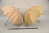 Three piece lot to include a Burberry plaid umbrella with wood handle along with Lancel paisley umbrella, along with a walking stick. stick lg: 37" . 