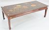 Chinese style coffee table with floral and bird decorative top. ht. 17 in., top: 24" x 52". Provenance: Estate of William and Teresa Patton, Lake Ave 