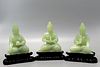 Three Chinese carved jade figures of Buddha on wood