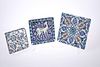 THREE IZNIK POLYCHROME POTTERY TILES, two with floral decoration, the third