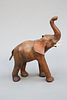 A VINTAGE LEATHER FIRESIDE MODEL OF AN ELEPHANT, modelled with truck aloft.