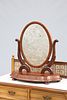 A VICTORIAN MAHOGANY TOILET MIRROR, the oval mirror plate swinging between 