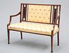 AN EDWARDIAN INLAID MAHOGANY SETTEE, with rectangular upholstered panel to 