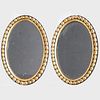 Pair of Small English Ebonized and Parcel-Gilt Oval Mirrors