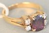 14k gold ring set with center oval ruby flanked b y 2 diamonds on either side, size 5.