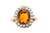 A CITRINE AND HALF PEARL RING
 The cushion-shaped citrine, within a florafo