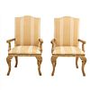 Par de sillones. Siglo XX. En talla de madera dorada. Con respaldos cerrados y asientos acojinados en tapicería rayada.