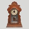 Reloj. Nueva York, Estados Unidos. SXX. En madera. Marca Ansonia Clock Co. Mecanismo de cuerda y péndulo. 59 x 37 x 13 cm.