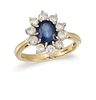 A SAPPHIRE AND DIAMOND CLUSTER RING
 The oval-cut 