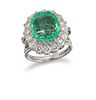 AN EMERALD AND DIAMOND CLUSTER RING
 Centred by a 