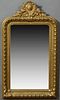 French Gilt and Gesso Overmantel Mirror, 19th c., with an arched shield and floral crest over a rounded corner frame with a large be...