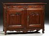 French Provincial Louis XV Style Carved Pine Sideboard, early 19th c., the lifting rounded corner and edge top over a storage area a...