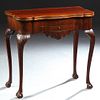 English Georgian Carved Mahogany Games Table, late 18th/ early 19th c., the shaped rounded corner folding top enclosing a compartmen...